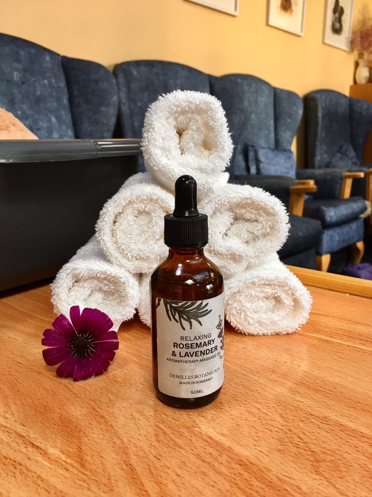 Rosemary and lavender oil and rolled towels ready for an aromatherapy session
