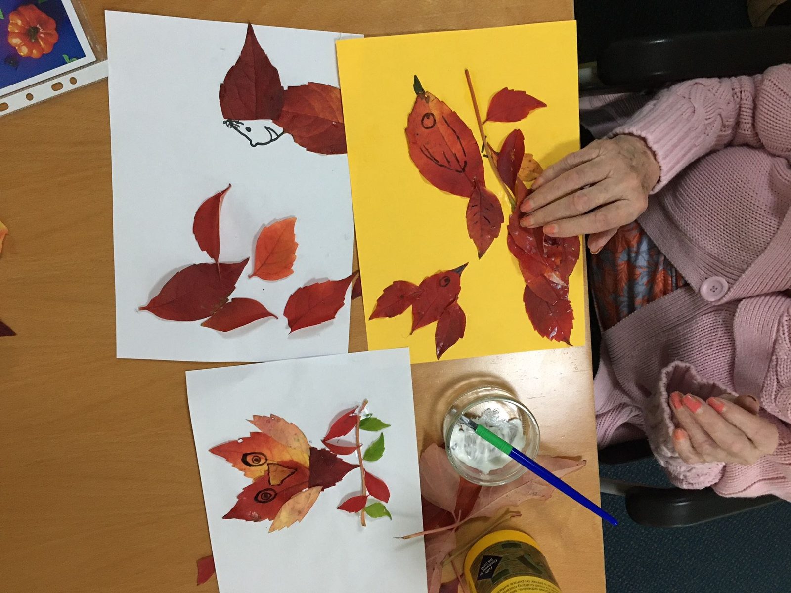A resident making autumn leaf pictures in an art session
