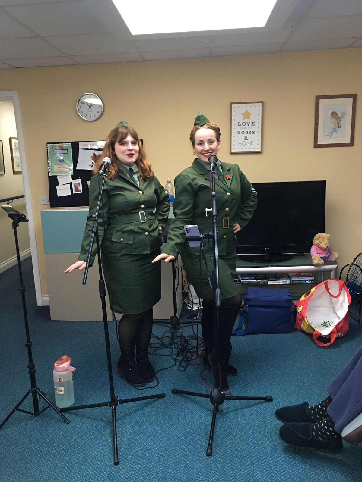 Two singers in 1940s uniform performing for residents in the lounge