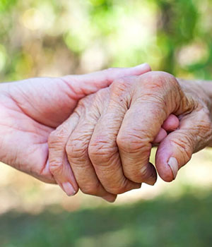 Carer holding a resident's hand